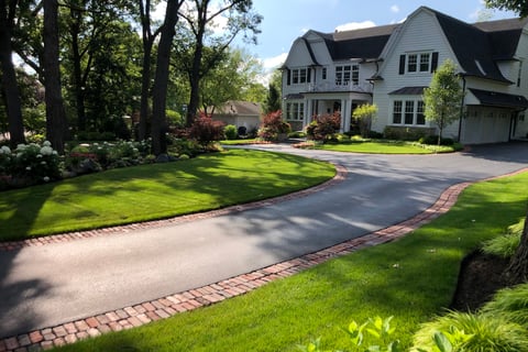 front of house with long drivway and beautiful landscaping